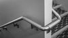 silver handrail curving around wall along staircases
