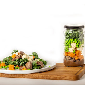 serving of Steak & Vegetables next to a jar