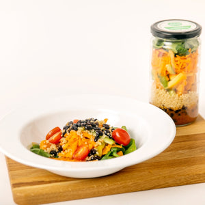 serving of Veggie Showdown next to a jar